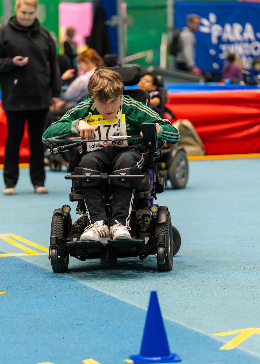 Nuori poika kiertää taitorataa sähköpyörätuolillaan.